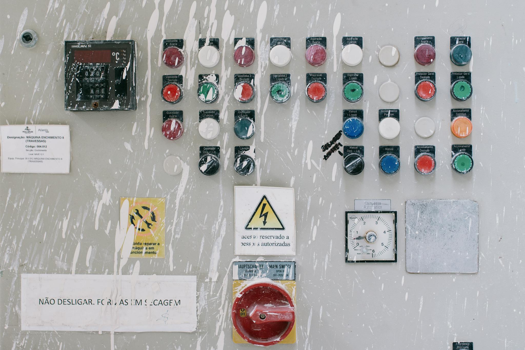 Close-up of an industrial control panel with colorful warning buttons and switches.